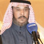 يرتدي عبدالله بن زويبن الحربي شماغًا أحمر وأبيض ولحية سوداء أمام ميكروفون خلال إلقاء قصيدة شعرية بنبرة مؤثرة.