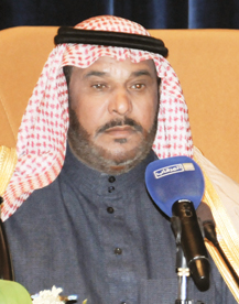يرتدي عبدالله بن زويبن الحربي شماغًا أحمر وأبيض ولحية سوداء أمام ميكروفون خلال إلقاء قصيدة شعرية بنبرة مؤثرة.